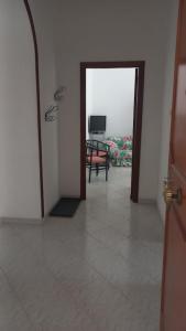 um corredor com uma porta que leva a um quarto com televisão em La Casa Dei Nonni em Nápoles