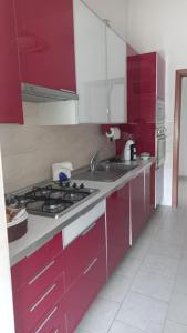 uma cozinha com armários vermelhos e um forno com placa de fogão em La Casa Dei Nonni em Nápoles