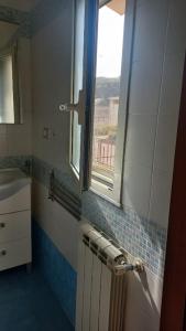 uma casa de banho com um lavatório e uma janela em La Casa Dei Nonni em Nápoles