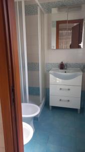 uma casa de banho com um lavatório, um chuveiro e um WC. em La Casa Dei Nonni em Nápoles