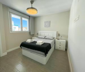 een witte slaapkamer met een bed en een raam bij Dunas de Marivilla by Spain2home in Torrox