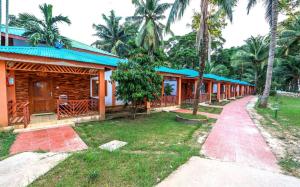 eine Reihe von Häusern mit Palmen und Bürgersteig in der Unterkunft Pearl Park Beach Resort Private Limited in Port Blair