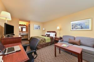 a hotel room with a bed a couch and a desk at Americas Best Value Inn San Jose in San Jose