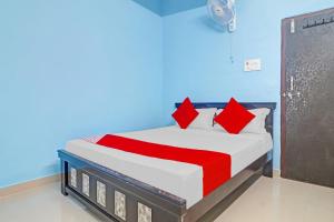 - un lit avec des oreillers rouges dans une chambre bleue dans l'établissement OYO Flagship Hanuma Residencies, à Hyderabad