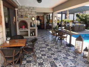a patio with a table and chairs and a pool at Fizzio Alaçatı Hotel in Alaçatı