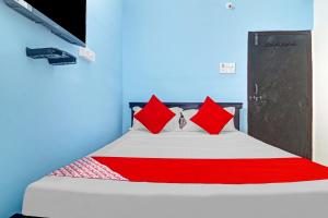 - une chambre avec un lit doté d'oreillers rouges dans l'établissement OYO Flagship Hanuma Residencies, à Hyderabad