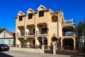 un edificio con balcones y un coche aparcado delante en Apartments Maky & Dino, en Vodice