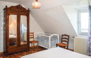 a bedroom with a crib and a mirror and chairs at Amazing Home In Kerbors With Wifi And 3 Bedrooms in Kerbors