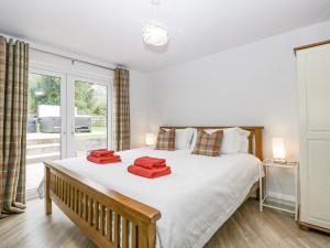 a bedroom with a large bed with red towels on it at Orchard House in Leominster