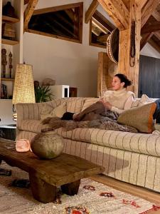 a man sitting on a couch in a living room at B&B Boutique Chalet Nono in Montriond