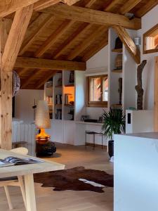 un soggiorno con soffitti in legno e tavolo di B&B Boutique Chalet Nono a Montriond