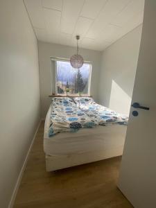 1 dormitorio con cama y ventana en Golden Circle private Farmhouse with hot tub, en Selfoss