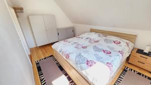 a small bedroom with a bed with a floral blanket at Ferienwohnung Am Wasserturm in Plau am See