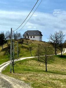 una casa en la cima de una colina con una carretera en Maramures BELVEDERE, en Petrova