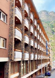 a brick building with balconies on the side of it at Hotel Folch in Sant Julià de Lòria