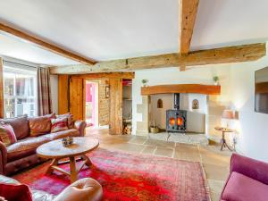 a living room with a couch and a fireplace at Holmeside Barn in Grewelthorpe