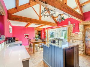 a kitchen with red walls and wooden beams at Holmeside Barn in Grewelthorpe