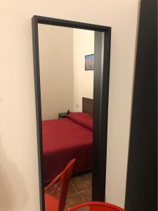 塔蘭托的住宿－Downtown Lodge Museum，配有红色床的客房内的镜子