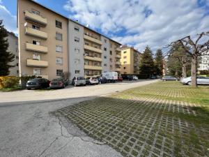 a street with cars parked in front of a building at Friendly Space Apartment in Graz