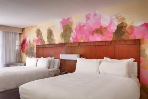 a hotel room with two beds and a colorful wall at Courtyard by Marriott Albuquerque in Albuquerque