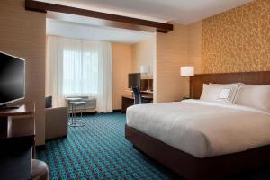 アマーストにあるFairfield Inn & Suites by Marriott Buffalo Amherst/Universityのベッドとテレビが備わるホテルルームです。
