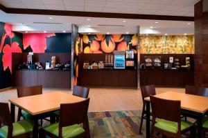 um restaurante com duas mesas e cadeiras e um bar em Fairfield Inn & Suites by Marriott Buffalo Amherst/University em Amherst