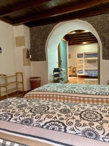 a bedroom with a bed with a stone wall at Casa Cueva - L&L in Santa Cruz de Tenerife