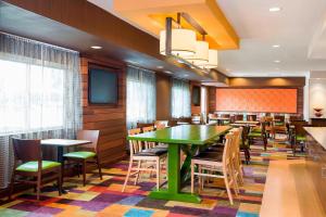 a restaurant with a green table and chairs at Fairfield Inn & Suites Dallas Park Central in Dallas