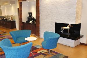 a lobby with blue chairs and a fireplace at Fairfield Inn & Suites Dallas Park Central in Dallas