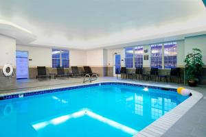 uma piscina num quarto de hotel com cadeiras e mesas em Residence Inn Colorado Springs South em Colorado Springs