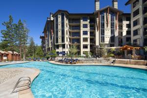 einem großen Pool mit Stühlen vor einem Gebäude in der Unterkunft The Westin Monache Resort, Mammoth in Mammoth Lakes