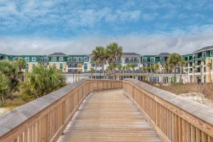 un paseo marítimo que conduce a la playa con apartamentos en condominio en Residence Inn by Marriott Jekyll Island en Jekyll Island