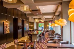 Residence Inn by Marriott Charlottesville Downtown في شارلوتسفيل: مطعم بطاولات وكراسي وبار