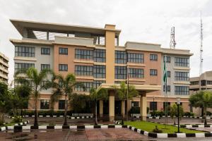 a building with palm trees in front of it at Protea Hotel by Marriott Ikeja Select in Ikeja
