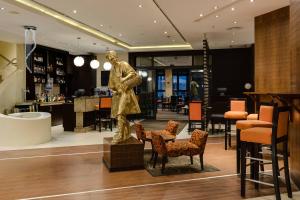 Protea Hotel by Marriott Ikeja Select في إيكيجا: تمثال رجل في لوبي مع كراسي
