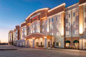 a large hotel building with an archway next to a street at Residence Inn by Marriott Dallas Plano/Richardson in Plano