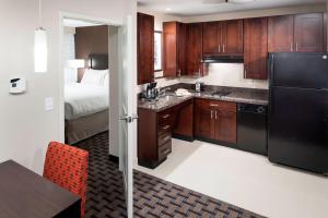 a kitchen with a sink and a refrigerator and a bed at Residence Inn by Marriott Dallas Plano/Richardson in Plano