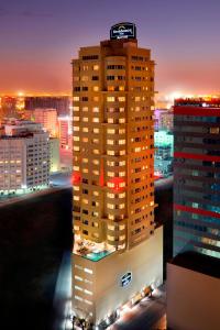 un edificio alto con un cartel encima de él por la noche en Residence Inn by Marriott Manama Juffair, en Manama