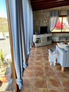 sala de estar con cortinas azules y sofá en Casa Cueva - L&L, en Santa Cruz de Tenerife