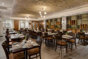 Protea Hotel by Marriott Cape Town Durbanville في بيل فيل: مطعم فيه طاولات وكراسي في الغرفة