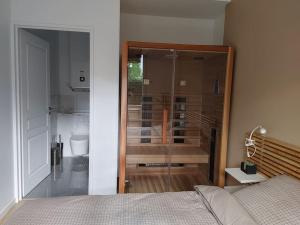 a bedroom with a bed and a glass shower backdoor at Cocon lumineux avec parking et sauna Paris direct in Asnières-sur-Seine