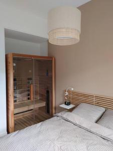 a bedroom with two beds and a chandelier at Cocon lumineux avec parking et sauna Paris direct in Asnières-sur-Seine
