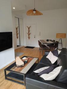 a living room with a couch and a table at Cocon lumineux avec parking et sauna Paris direct in Asnières-sur-Seine