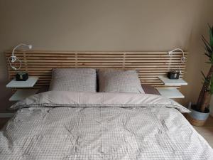 a bedroom with a bed with a wooden headboard at Cocon lumineux avec parking et sauna Paris direct in Asnières-sur-Seine