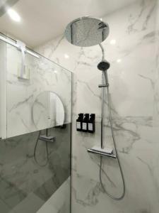 a shower in a bathroom with a glass door at Cocon lumineux avec parking et sauna Paris direct in Asnières-sur-Seine