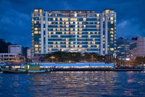 a large building with a boat in front of it at Le Meridien Kota Kinabalu in Kota Kinabalu