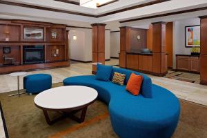 a living room with a blue couch and a table at Fairfield Inn and Suites by Marriott Dallas Mansfield in Mansfield