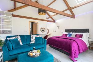 a bedroom with a bed and a blue couch at Shepherds View in Dufton