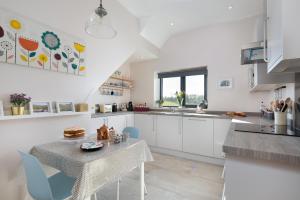 a kitchen with white cabinets and a table and chairs at Shepherds View in Dufton