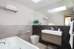 a bathroom with a tub and a sink and a toilet at Shepherds View in Dufton +13 photos